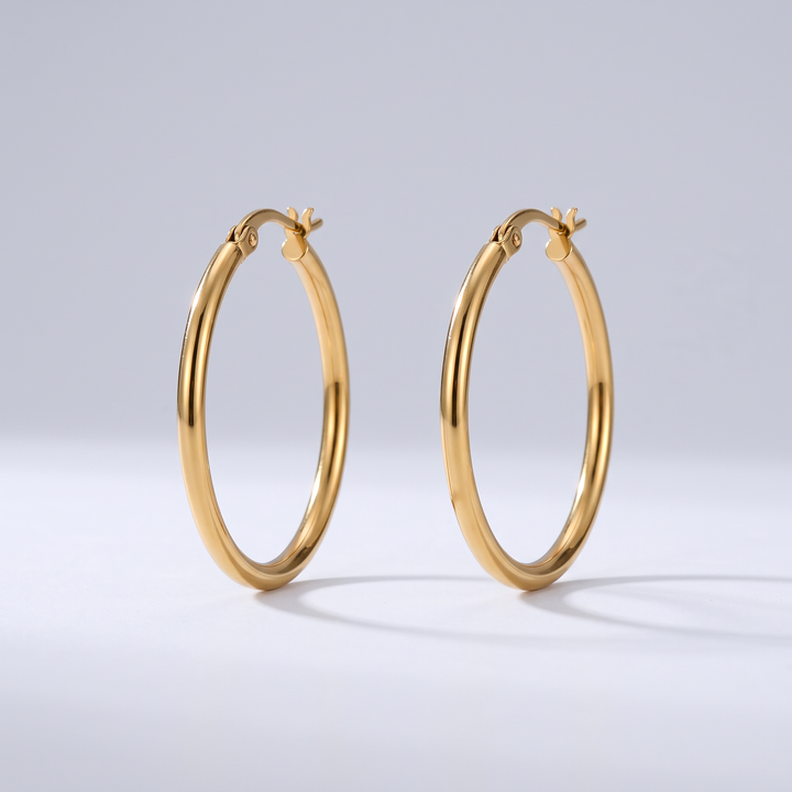 Everyday Hoops: pair of thin plain round gold-tone hoop earrings, front view on grey studio background