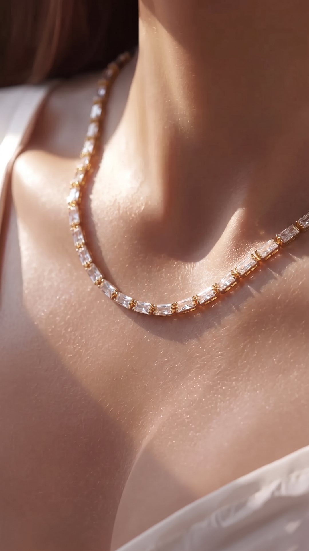 Close-up of the Classic Tennis Necklace worn around the neck in sunlight