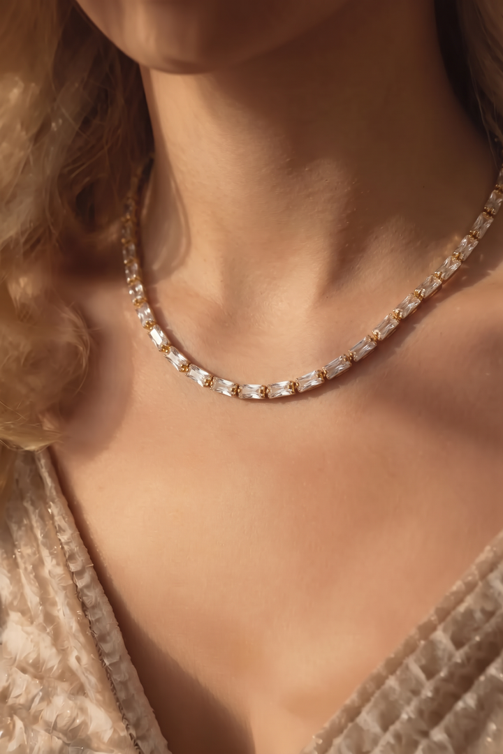 Model with a beige knit top wearing the gold-tone Classic Tennis Necklace