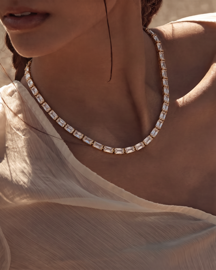 Model in a white top wearing the Classic Tennis Necklace at the base of the neck