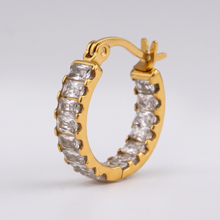 Close-up of the clear baguette-cut zirconia stones and hinge of the Tennis Huggie Hoop