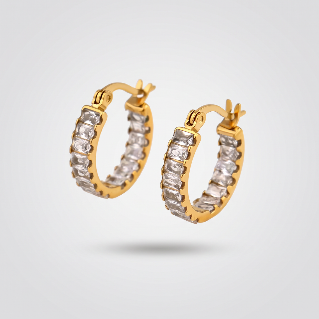 Tennis Huggie Hoops in gold-tone with a row of clear zirconia stones, pair on a light grey background