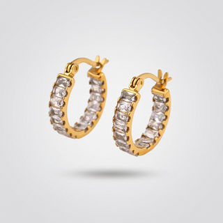 Tennis Huggie Hoops in gold-tone with a row of clear zirconia stones, pair on a light grey background