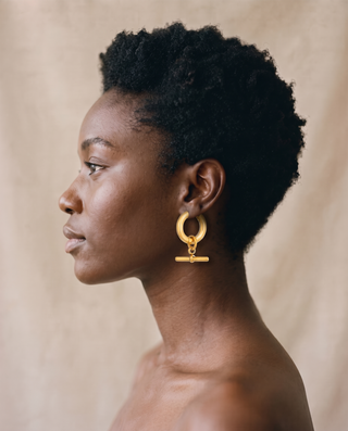 Model with short natural hair wearing a gold-tone T-Bar Hoop earring, side profile