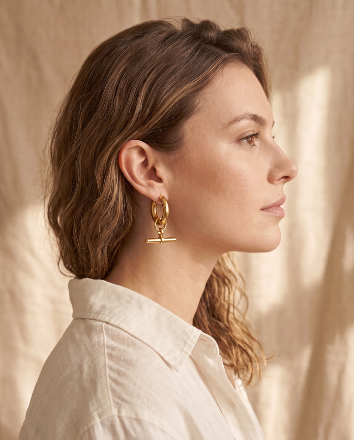 Model wearing a gold-tone T-Bar Hoop earring, side profile